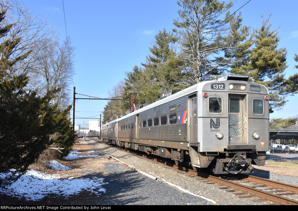 Early afternoon run of NJTs Princeton Dinky approaching the Faculty Road Grade Crossing in Princeton 